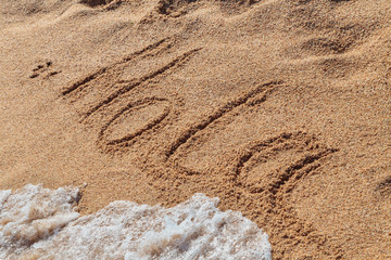 inscription HOLA on the beach sand © KPad