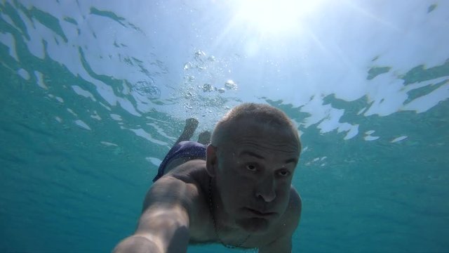 Man swimming underwater.