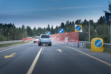 Sign of detour travel. Pit on the road. repair work. cars drive around the work zone
