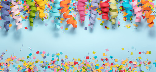 Streamers and confetti on blue background.Birthday decoration. - obrazy, fototapety, plakaty