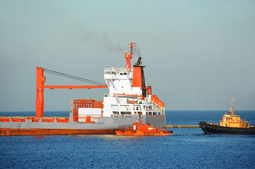 Tugboat assisting bulk cargo ship