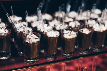 Rows of chocolate mousse in shot glasses. Selective focus. Copy space.