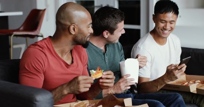Male friends eating different takeout meals together
