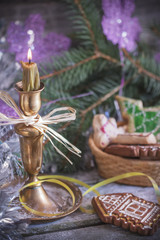 Gingerbread cookies,  candle  and Chrismas decorations over wooden background