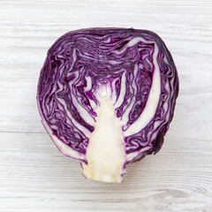 Obraz premium Half of red cabbage on white wooden table, top view. From above, overhead, flat lay. Close-up.
