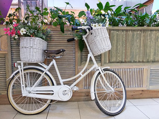 Fototapeta na wymiar Bicycle with flowers basket. Girl bike in the shopping mall