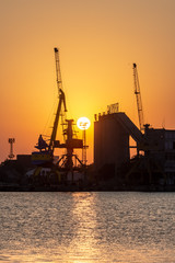 Fototapeta premium Port with cranes at sunset. 