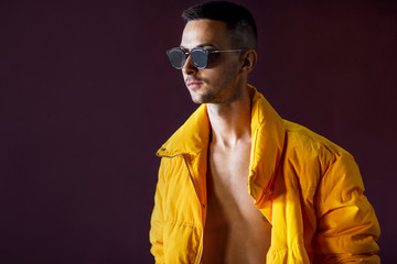 fashion guy standing near a viola wall in yellow clothes