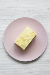 Piece of Napoleon Cake on pink plate over white wooden background, top view. Flat lay, from above, overhead.