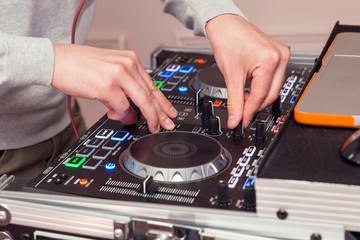 Naklejka premium DJ hands on music mixer