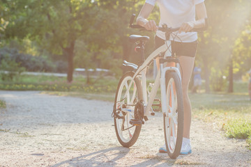 Young sporty woman with a bike, soft focus background