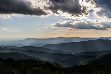 Fototapeta na wymiar Shenandoah Valley National Park on a hazy summer day as the light breaks through the clouds casting shafts of light