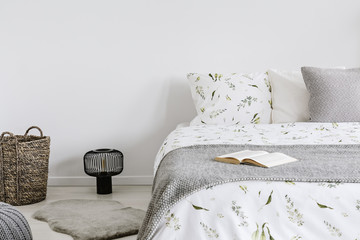 close-up of a bed with eco cotton and wool bedding and pillows in a bright bedroom interior. Real...