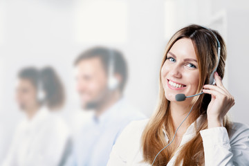 Happy and smiling woman with microphone during telemarketing job - obrazy, fototapety, plakaty