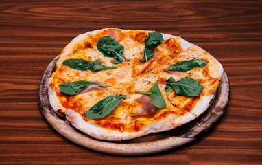 Italian margherita pizza with parma ham basil on wood table
