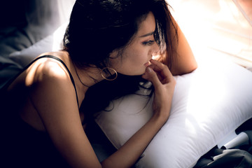 Fototapeta premium Asian adult sexy lady with big breast in black bikini lie on a pillow on the bed