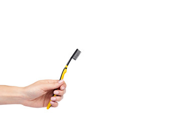 Black and yellow soft toothbrush with hand isolated on white background, copy space template