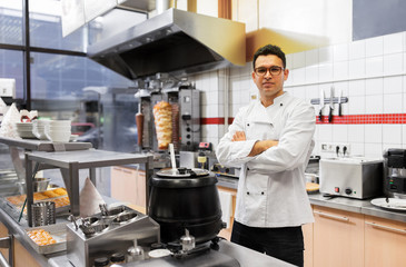 people, fast food and cooking concept - chef at kebab shop