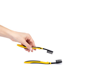 Black and yellow soft toothbrush with hand isolated on white background, copy space template
