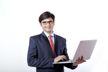 Young Indian businessmen using laptop over isolated background.