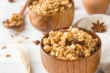Dry Breakfast of oat flakes, granules and nuts. Muesli in a deep wooden plate.