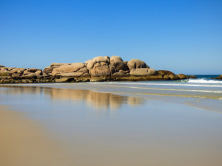 Fototapeta premium Rocky shore and transparent waters at Praia da Galheta (Galheta beach) in Florianopolis, Brazil