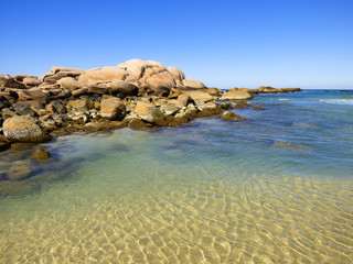 Rocky shore and transparent waters at Praia da Galheta (Galheta beach) in Florianopolis, Brazil