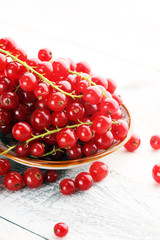 Fresh red currants on light rustic table. Healthy summer fruits