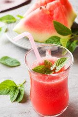 Fresh watermelon smoothie with ice and mint leaves in glasses.