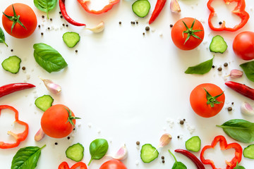 Colorful salad ingredients pattern made of tomatoes, pepper, chili, garlic, cucumber slices and  basil on white background. Cooking concept. Top view. Flat lay. Copy space