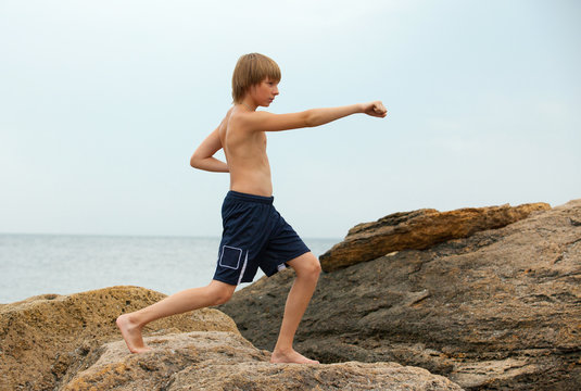 Boy practicing karate on the seashore