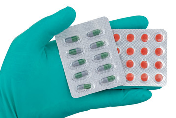 Medic's hand and blister of pills on white