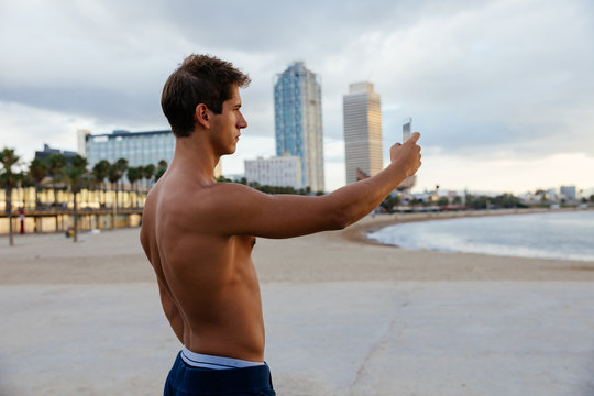 Athlete man taking a picture with the mobile.