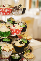 Colourful cupcakes at an event presented on a cake stand.