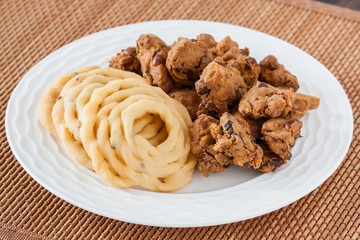 Indian murukku and pakoda snack - A closeup of traditional deep fried Indian snacks murukku and nuts pakkoda on a plate.