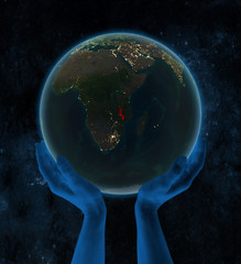 Malawi on night Earth in hands in space