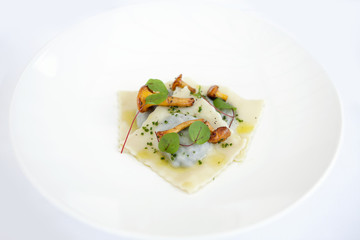 Pasta ravioli starter on a white plate.
