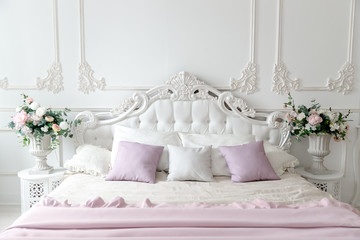 Classic bedroom with white bed, carriage-bed, pillows for head.