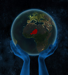 Niger on night Earth in hands in space