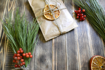 branch of a Christmas tree and gift on wooden background