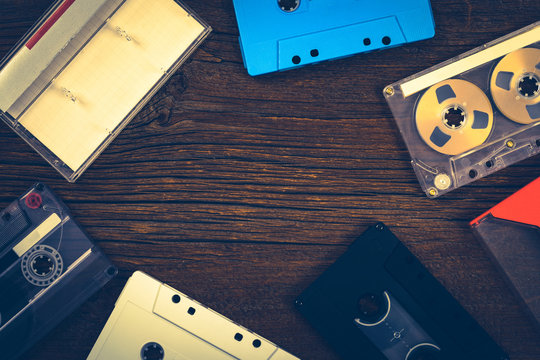 Compact Audio Cassette Tape on Wooden Background with Copy Space. Photo in retro style. Toned image.