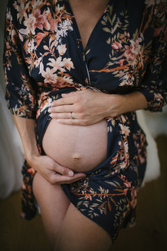 Midsection of pregnant woman touching her belly