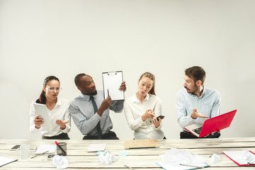 Young african and caucasian men and women sitting at office and working on laptops. The business,...