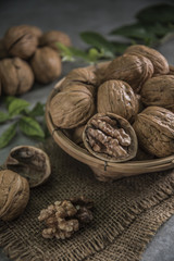 Walnuts in wooden bowl. Whole walnut on table
