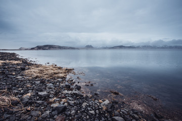 Icelandic landscape with a lake and mountains in cloudy overcast weather