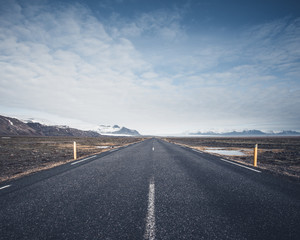 Road leading towards mountains in vast open landscape