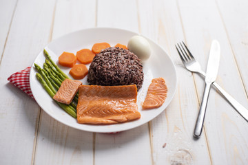 Health food concept, salmon with rice and vegetable on wood background
