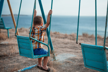 Child on a swing near the sea