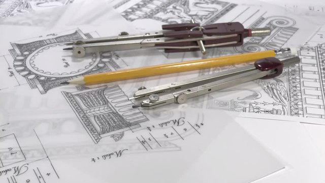 Workplace Architect: professinoalny tools - pencil and compasses rotate slowly in the drawings of elements of ancient architecture