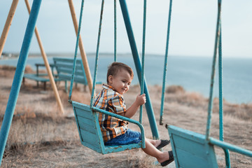 Child on a swing near the sea